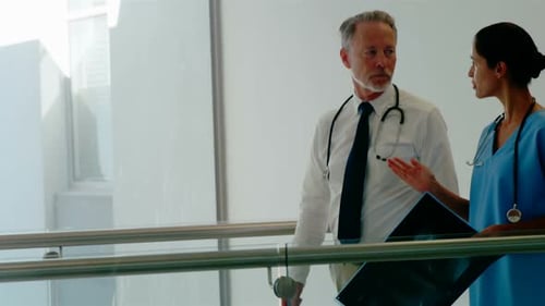 Médecins caucasiens, hommes et métisses, travaillant ensemble dans un centre médical, marchant et parlant
