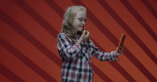 Girl Applies Lipstick Using Phone as Mirror