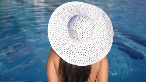 Woman with Sun Hat by the Pool