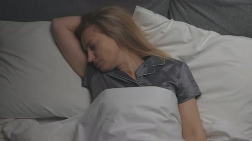 Woman Wakes Up and Stretches in Bed