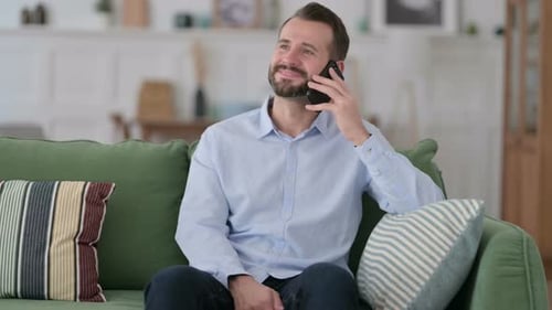 Man Talking on Phone on Couch at Home