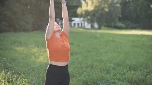 Woman Doing Yoga in Grassy Field on Sunny Day