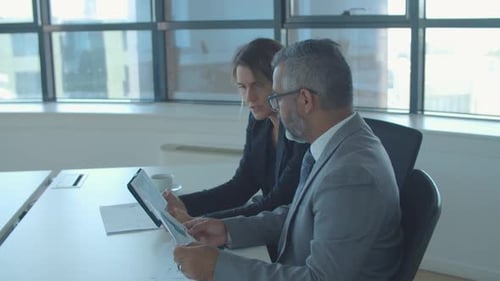 Business Colleagues Discussing Project with Tablet