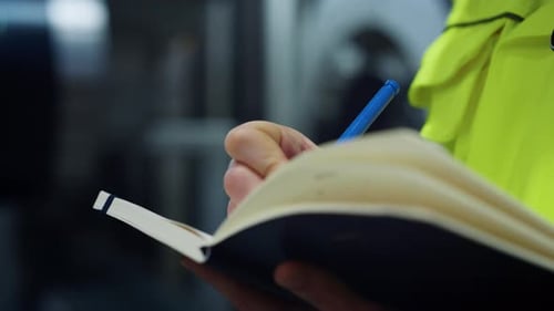 Woman Hands Writing Data in Notebook on Big Logistic Company Closeup