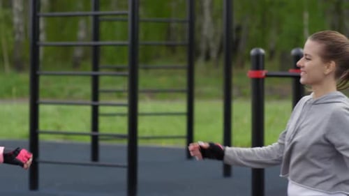 Caucasian Twin Girls Giving High-Fives during Workout in Park