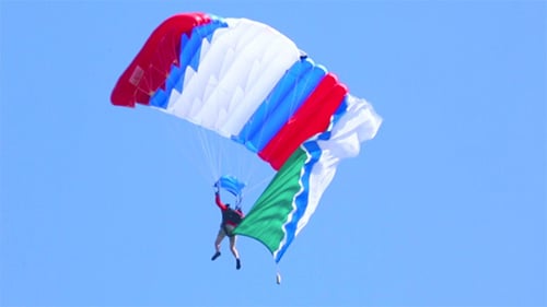 Skydiver Parachuting with Flags on a Sunny Day