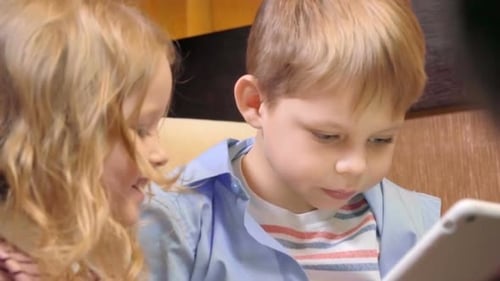 Blonde Children Using Tablet Together Indoors