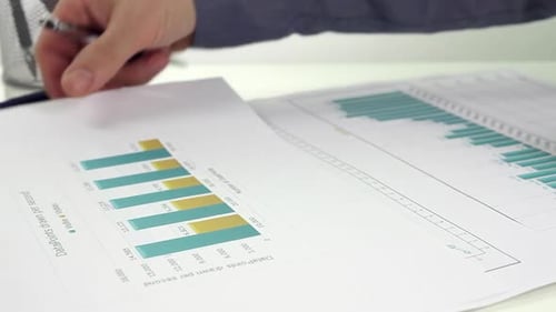Man Analyzing Business Charts and Graphs at Desk