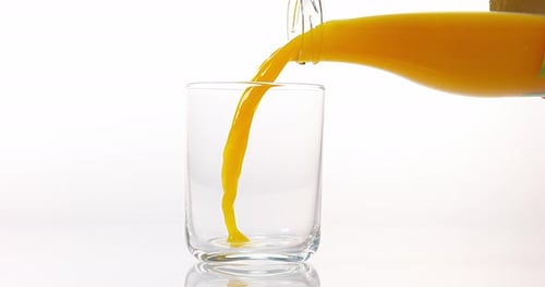 Pouring Fresh Orange Juice into Glass