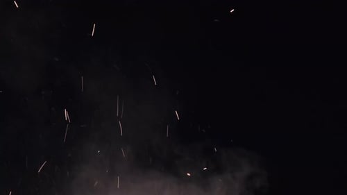Campfire Sparks Rise Up Against Black Background. Slow Motion