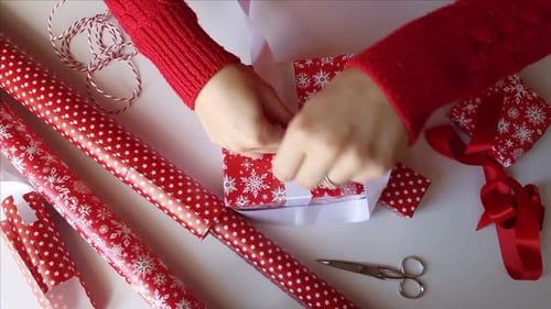 Hands Tying Ribbon on Christmas Gift Box
