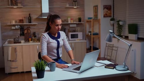 Woman Working on Laptop in Home Kitchen