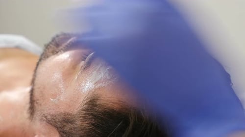 Wellbeing, Healthcare Concept. Man Lying on Couch at Beauty Clinic Getting Facial Treatment