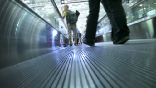 Passengers on Moving Walkway in Urban Airport Terminal