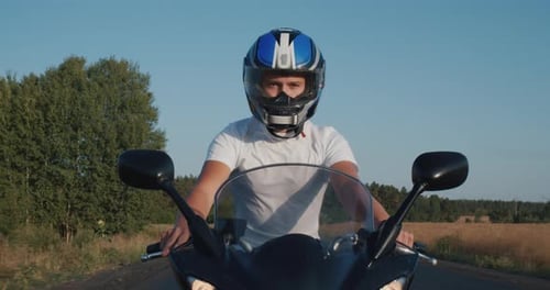Young Man Rides a Motorcycle on the Highway