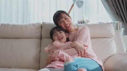 Mother and Daughter Cuddling Together on Couch