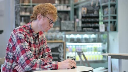 Young Redhead Man Drinking Water, Sitting in Cafe,