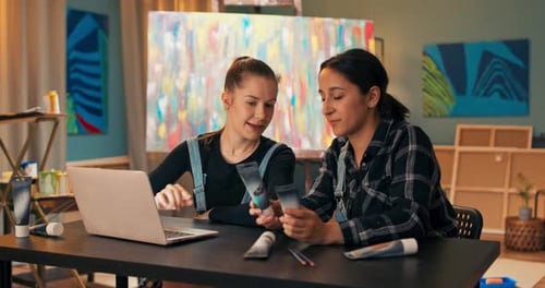 Young Adults Collaborate in Art Studio with Laptop