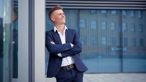 Man in Suit Smiling near Glass Building