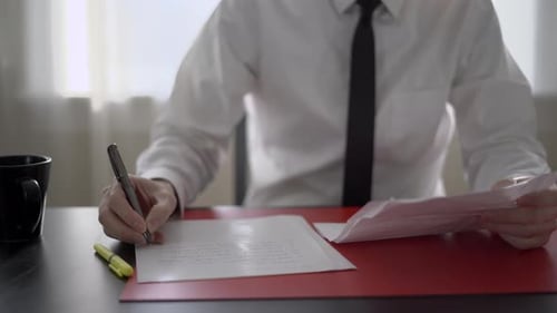 Mann macht sich Notizen an seinem Schreibtisch