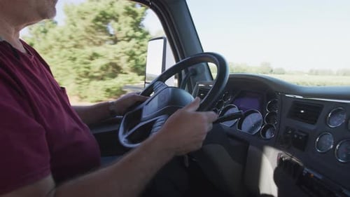 Interior shot of truck driver driving semi truck. Fully released for commercial use.