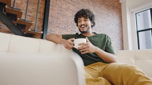 Indian Man Watches Funny Show on Laptop Drinking Coffee