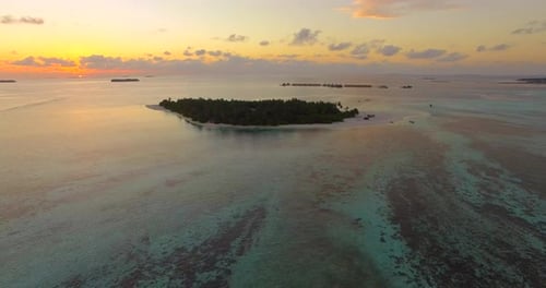 Aerial drone view of a scenic tropical island in the Maldives at sunset