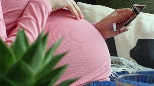 Pregnant Woman looks at Ultrasound Images at Home