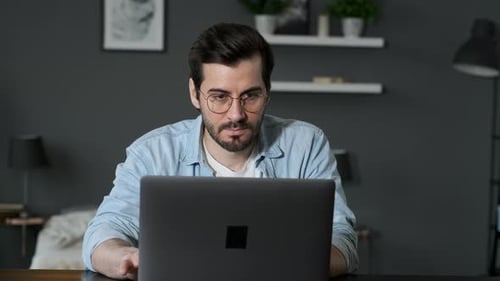 Man Works on Laptop at Home