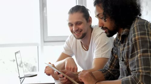Two Men Collaborating on Technology at Work