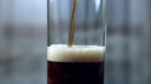 Dark Soda Beverage Pouring into Glass Close Up
