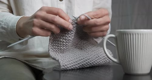 Hands Knit Gray Yarn in a Home