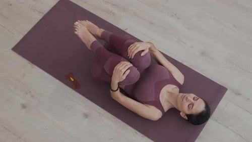 Woman Stretching Legs on Yoga Mat Indoors