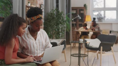 Woman and Child Using Laptop Together Indoors