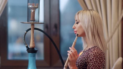 Attractive Woman Smoking Hookah in Relaxed Setting