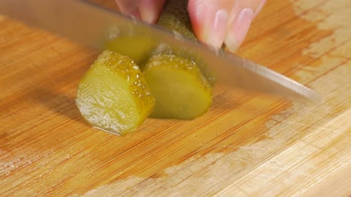 Pickle Sliced with Knife on Cutting Board