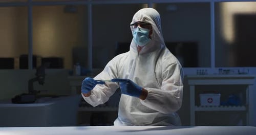 Scientist in Hazmat Suit Examines Sample in Lab