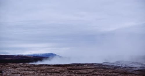 Steam Rising From Thermal Pool In Landscape