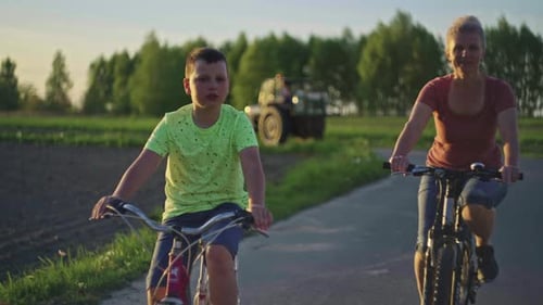 Family Cycling in a Field at Sunset
