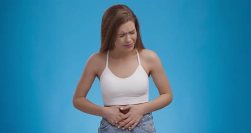Young Woman Experiencing Stomach Pain, Suffering From Severe Pain and Cramp in Lower Abdomen