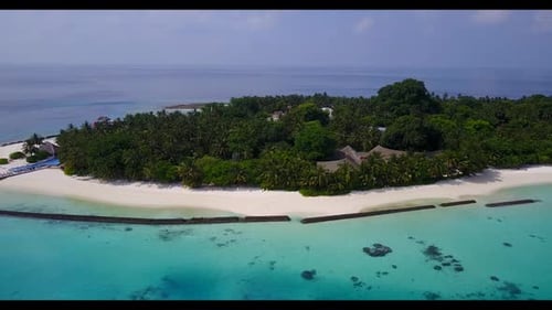 Aerial drone shot seascape of tranquil seashore beach trip by blue ocean with white sandy background