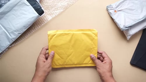 Hands Holding Yellow Padded Shipping Envelope