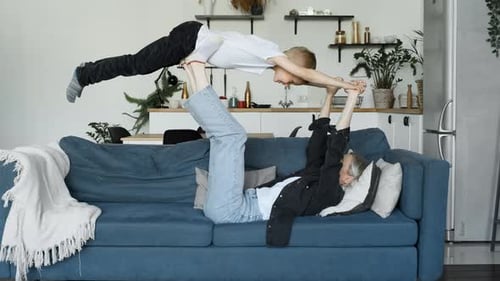 Woman and Child Play Acroyoga on Couch