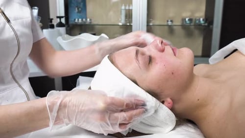 Woman Receiving Facial Cleaning Treatment at Spa