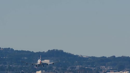 Airplane on Final Approach Over City Landscape