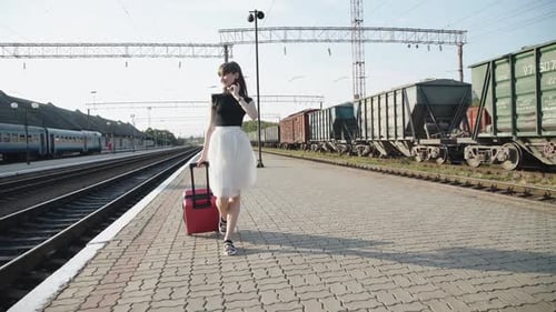 Woman Walks with Suitcase on Train Platform