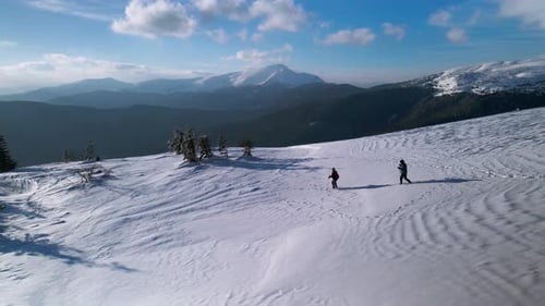 Drone Circle Around Couple of Hikers Walking on Mountain Ridge