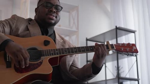 Man Plays Acoustic Guitar and Sings a Song