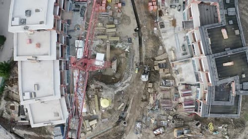 Overhead view of red steel cranes at a residential construction site.