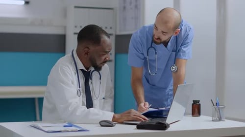 Doctors Collaborating on Laptop in Office Setting